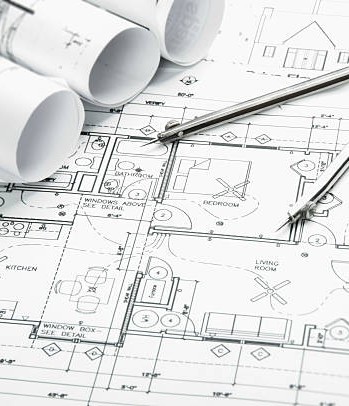 Construction planning drawings on the table and two yellow pencils